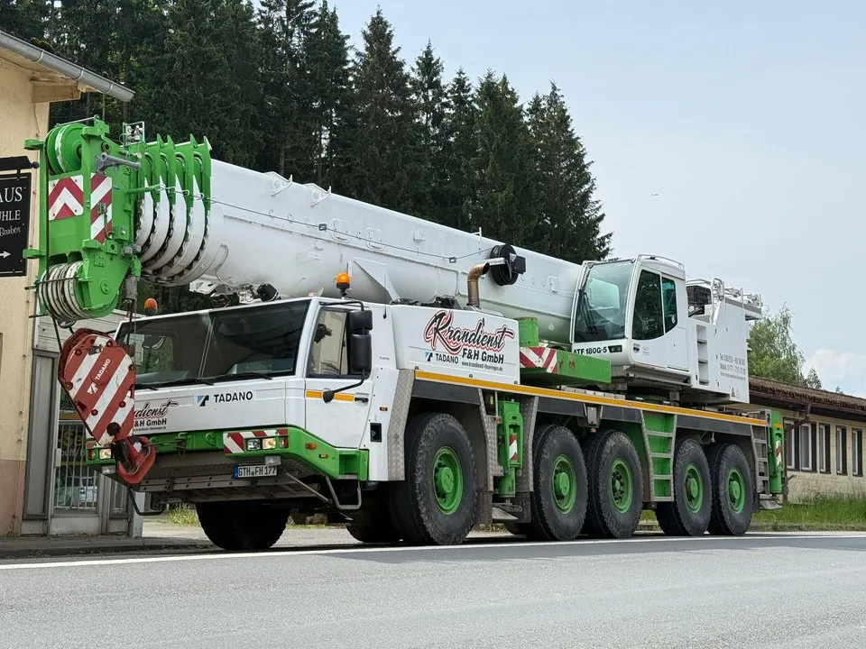 Fünfachsiger Autokran in Weiß und Grün von vorn