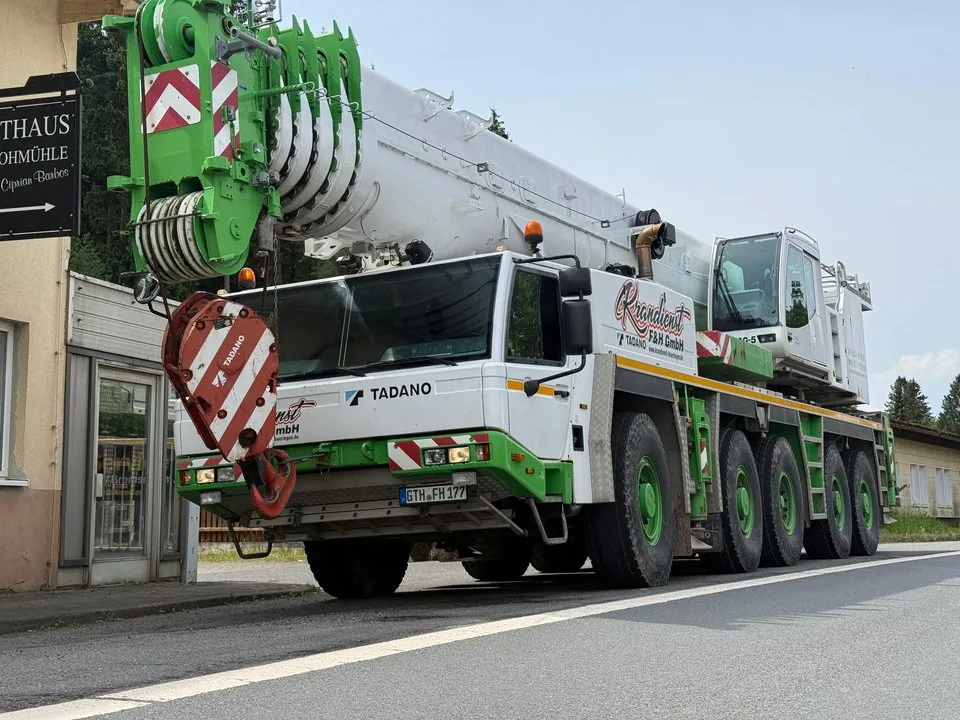 Autokran mit eingefahrenem Ausleger am Straßenrand